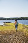Woman walking by lake, selective focus — Stock Photo