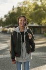 Porträt eines lächelnden Teenagers, der auf der Straße läuft — Stockfoto