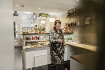 Mujer usando el teléfono inteligente en la cafetería, enfoque selectivo - foto de stock