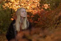 Adolescente chica por los árboles de otoño - foto de stock