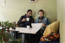 Young men working together in cafe — Stock Photo