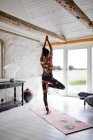 Woman practicing yoga in living room — Stock Photo