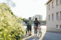 Couple avec vélos dans la rue de banlieue — Photo de stock