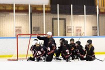 Mädchen hören ihrem Trainer beim Eishockey-Training zu — Stockfoto