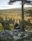 Mann sitzt auf Felsen im Naturreservat Tofsingdalen in Schweden — Stockfoto