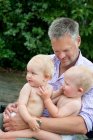 Glücklicher reifer Mann hält seine Kinder im Freien — Stockfoto