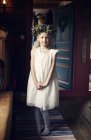 Fille portant une robe blanche et une couronne fleurie — Photo de stock