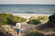 Ragazzo e ragazza a piedi dalla spiaggia, attenzione selettiva — Foto stock