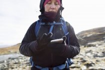 Woman using smart phone while hiking, selective focus — Stock Photo