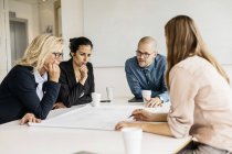 Empresários olhando para os planos durante a reunião — Fotografia de Stock