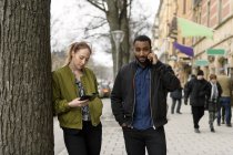 Пара, використовуючи смартфони на тротуарі, вибірковий фокус — стокове фото