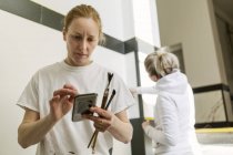 Painter checking smart phone, selective focus — Stock Photo