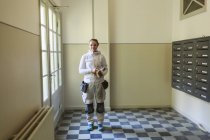 Maler steht an Briefkästen und blickt in Wohnhaus in die Kamera — Stockfoto