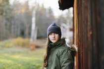 Mädchen trägt Mütze an Holzwand — Stockfoto