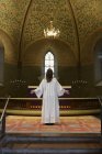 Priest in white robes standing at chancel in church — Stock Photo