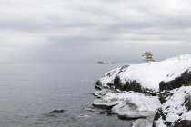 Vista panorámica de la nieve sobre rocas por mar - foto de stock