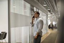 Giovane uomo utilizzando smart phone in corridoio — Foto stock