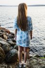 Young woman standing on shore of lake — Stock Photo