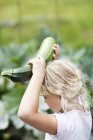 Girl holding courgette, selective focus — Stock Photo