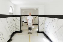 Pintor de pie en el pasillo del edificio de apartamentos - foto de stock