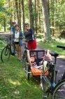Famille avec vélos passer du temps ensemble dans la forêt — Photo de stock