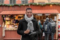 Портрет молодого чоловіка, який посміхається перед камерою, стоячи на ринку. — стокове фото