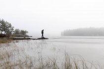 Uomo su rocce nel lago ghiacciato di Lotorp, Svezia — Foto stock