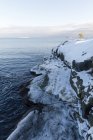 Живописный вид снега на скалах по морю — стоковое фото