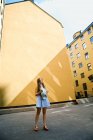 Девочка-подросток в синей шляпе напротив зданий — стоковое фото