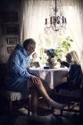 Nonno e nipote a tavola con fiori — Foto stock
