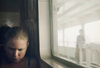 Молодая женщина сидела у окна в поезде — стоковое фото