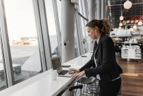 Mujer usando el ordenador portátil en el aeropuerto, enfoque selectivo - foto de stock