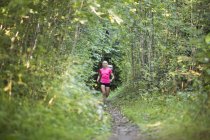 Donna che corre nella foresta, attenzione selettiva — Foto stock