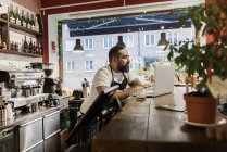 Mittlerer erwachsener Mann arbeitet im Café mit Laptop — Stockfoto