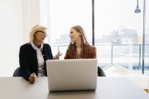Businesswomen with laptop, focus on foreground — Stock Photo
