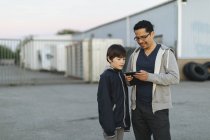 Father and son using smart phone — Stock Photo
