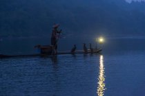 Homme pagayant sur le radeau au crépuscule dans le Sichuan, en Chine — Photo de stock