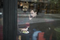 Молодий чоловік сидить у кафе, вибірковий фокус — стокове фото