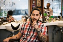 Portrait of barber sitting in barbers chair — Stock Photo