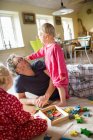 Man playing with his daughters at home — Stock Photo