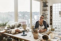 Frau am Schreibtisch in Töpferwerkstatt, selektiver Fokus — Stockfoto