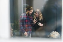 Coworkers looking at smartphone in office, selective focus — Stock Photo