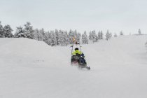 Hombre en moto de nieve, enfoque selectivo - foto de stock