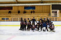 Chicas escuchando a su entrenador durante el entrenamiento de hockey sobre hielo - foto de stock