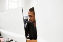 Взрослый мужчина, пользующийся компьютером в офисе — стоковое фото