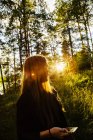 Jovem mulher na floresta ao pôr do sol — Fotografia de Stock