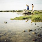 Dos chicas de pie junto al lago, enfoque selectivo - foto de stock