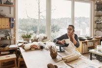 Frau am Telefon in Töpferwerkstatt, selektiver Fokus — Stockfoto