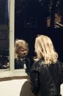 Mädchen und ihr Spiegelbild im Fenster — Stockfoto