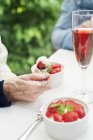 Senior woman eating strawberries, selective focus — Stock Photo